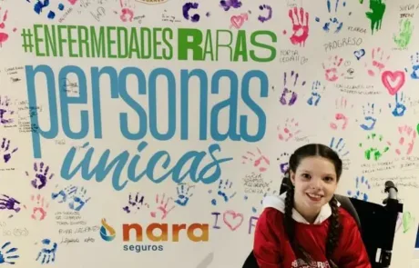 Carolina vor dem Wandbild „#EnfermedadesRaras, personas únicas“, das von den Fans des C.D. Leganés signiert wurde.