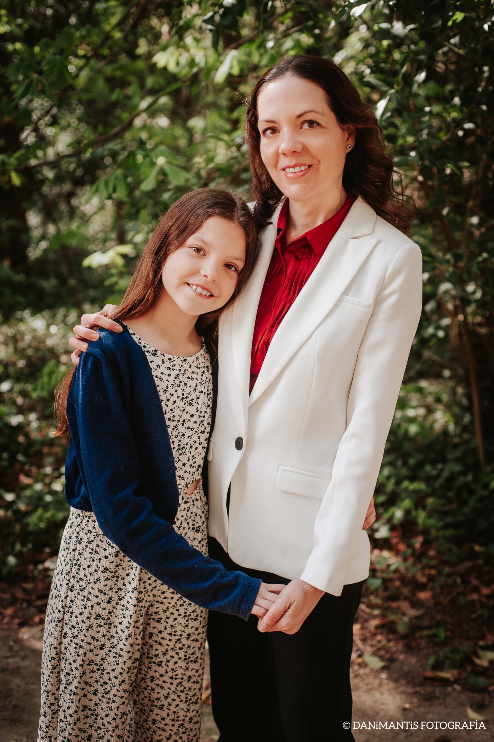 Laura und Isabel, Mutter und Tochter und Autorinnen von Carolina Purpurina, posieren umarmt in einem Garten.