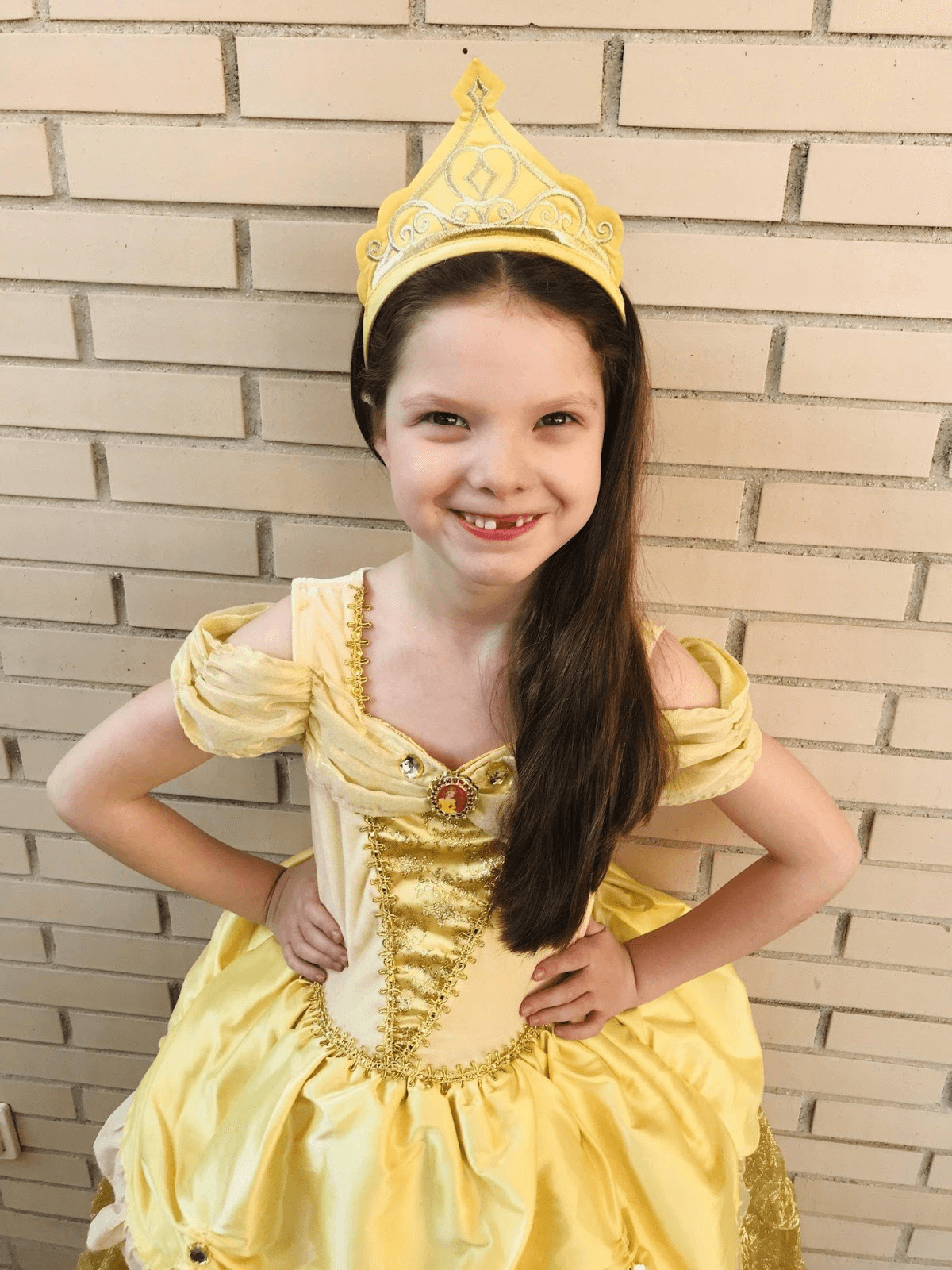 Carolina Purpurina als Prinzessin Belle verkleidet, mit gelbem Kleid und Krone, im Alter von sechs Jahren.