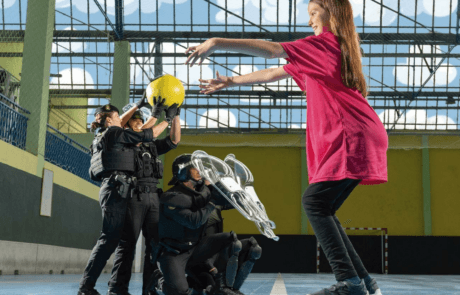 Foto aus dem ELA-Kalender 2024: Carolina wirft in einer Halle Beamten der Guardia Civil einen Ball zu.