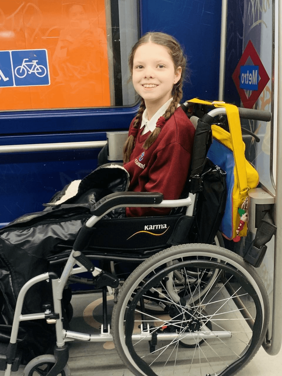 Carolina, in ihrem Rollstuhl und in der Schuluniform, fährt jeden Tag mit der U-Bahn in Madrid.