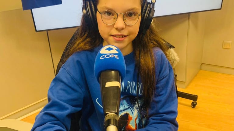 Isabel spricht mit Kopfhörern und Sweatshirt von „Carolina Purpurina“ vor dem Mikrofon von COPE im Studio.