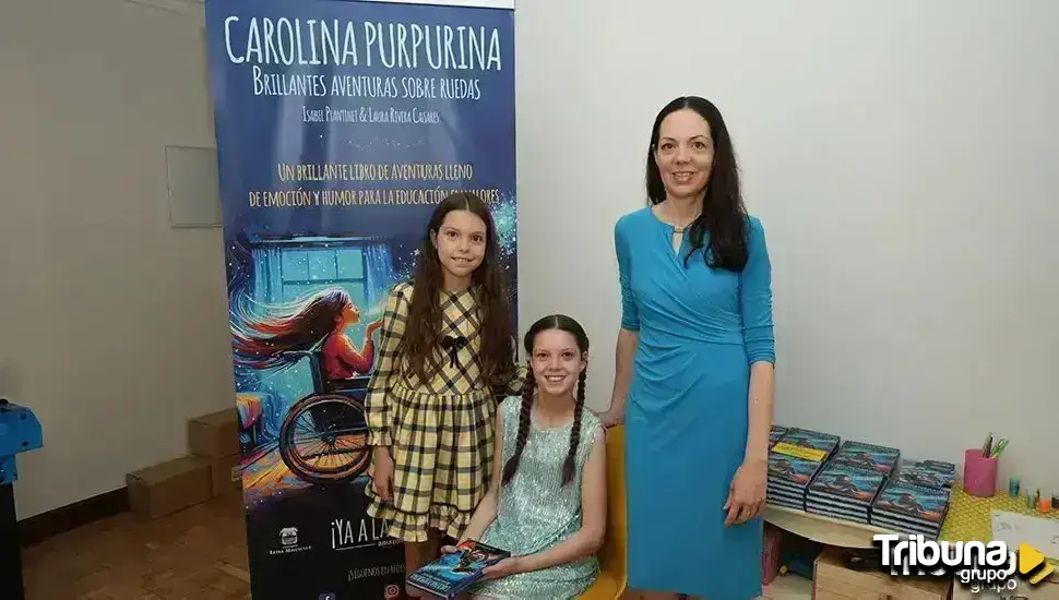 Zwei Mädchen und eine Frau posieren vor dem Roll-up von „Carolina Purpurina“; rechts Stapel von Exemplaren auf einem Tisch.